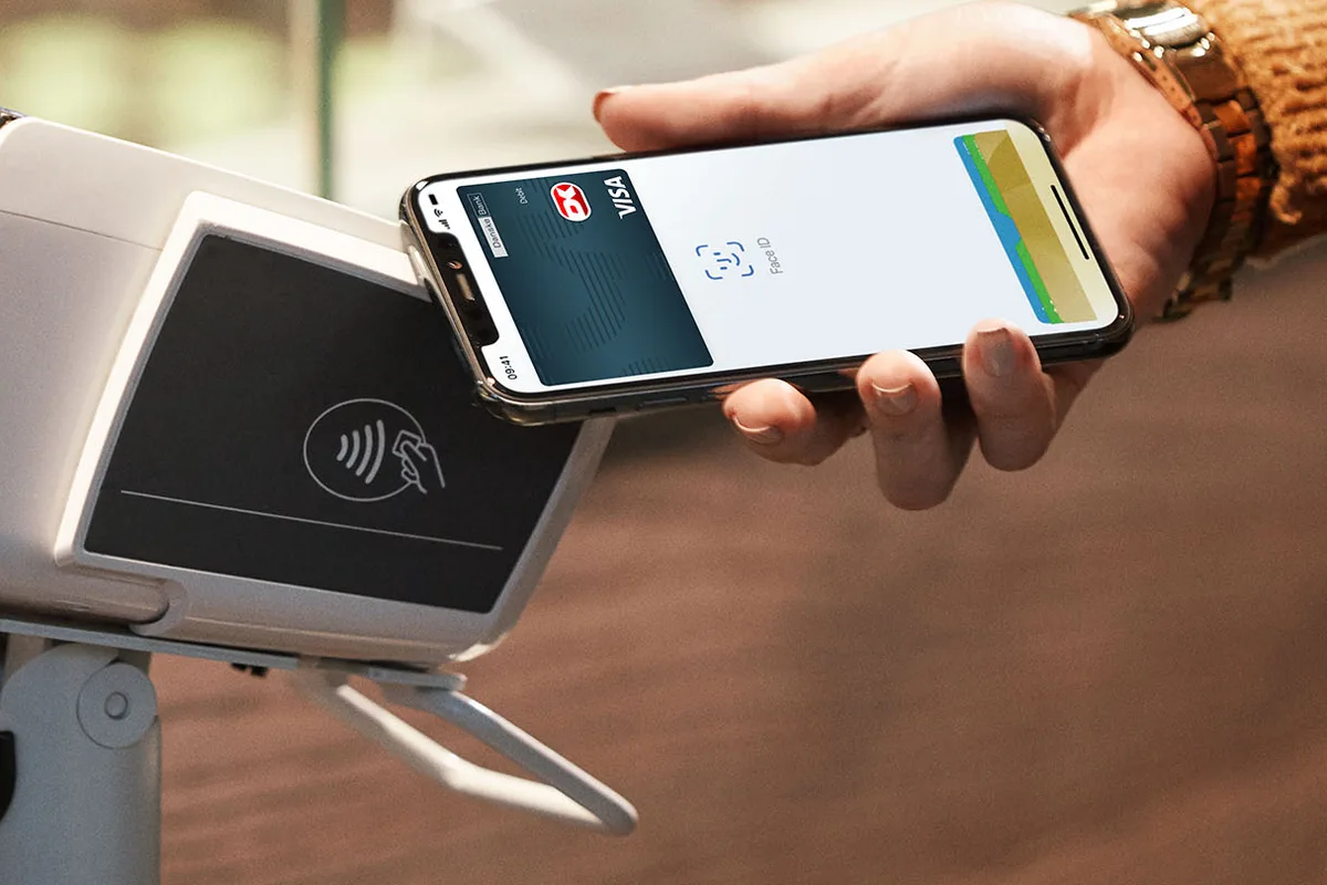Paiement Apple Pay avec un smartphone présenté devant un terminal sans contact